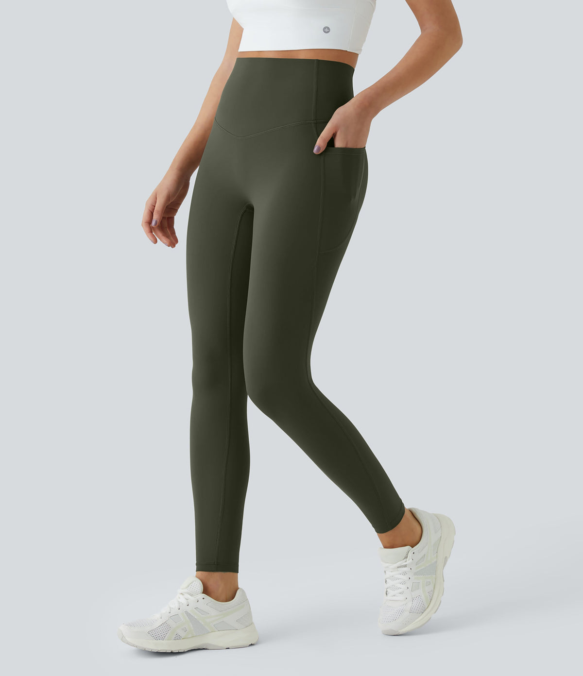Side three-quarter view of Celeste L'Amour Deep Woodland Green leggings with a hand resting in the side pocket
