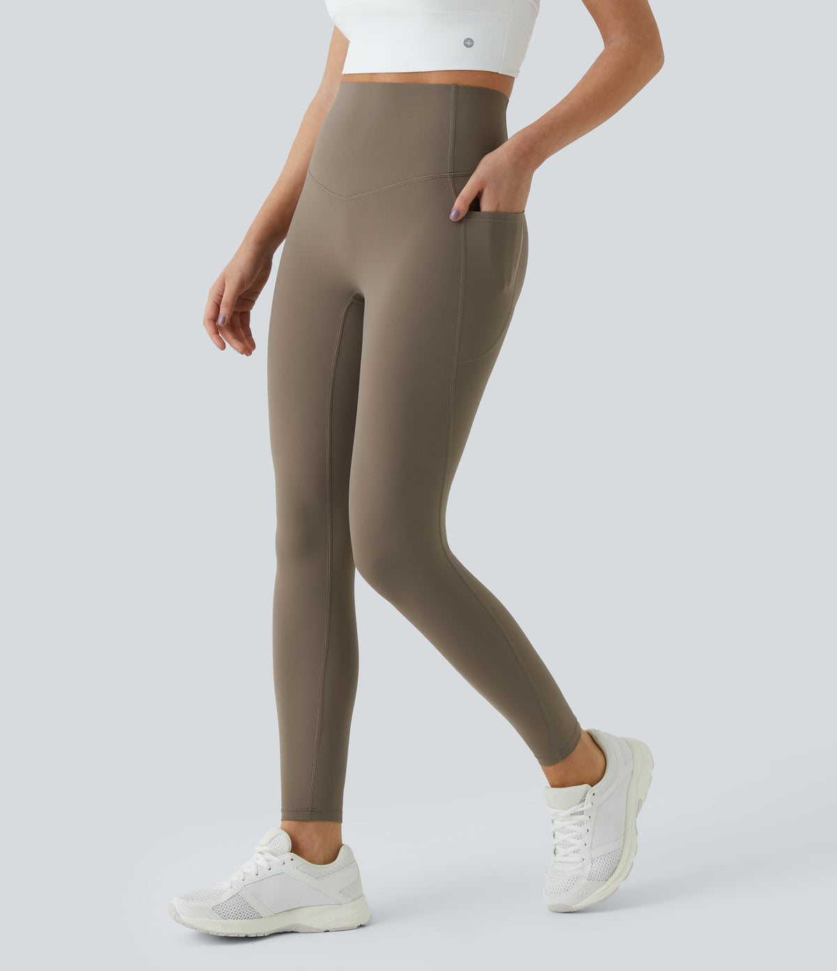 Side three-quarter view of Celeste L'Amour Dawn Brown leggings with a hand resting in the side pocket